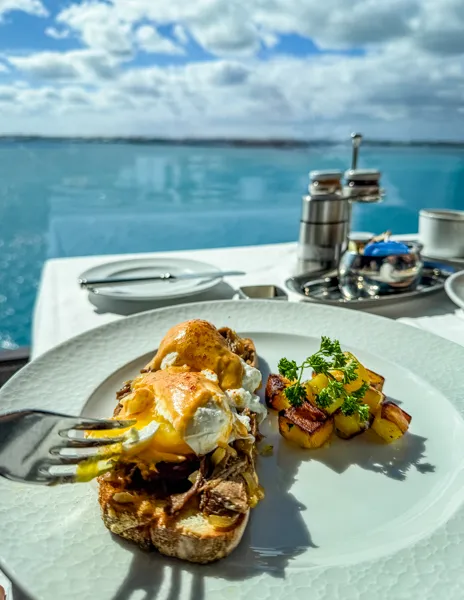 Beef short rib Benedict at Norwegian Aqua The Haven Restaurant with ocean views.
