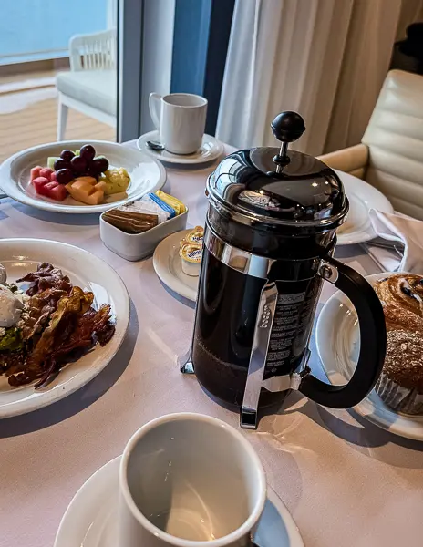 French press coffee served with breakfast, fruit, and pastries in an NCL Haven suite.