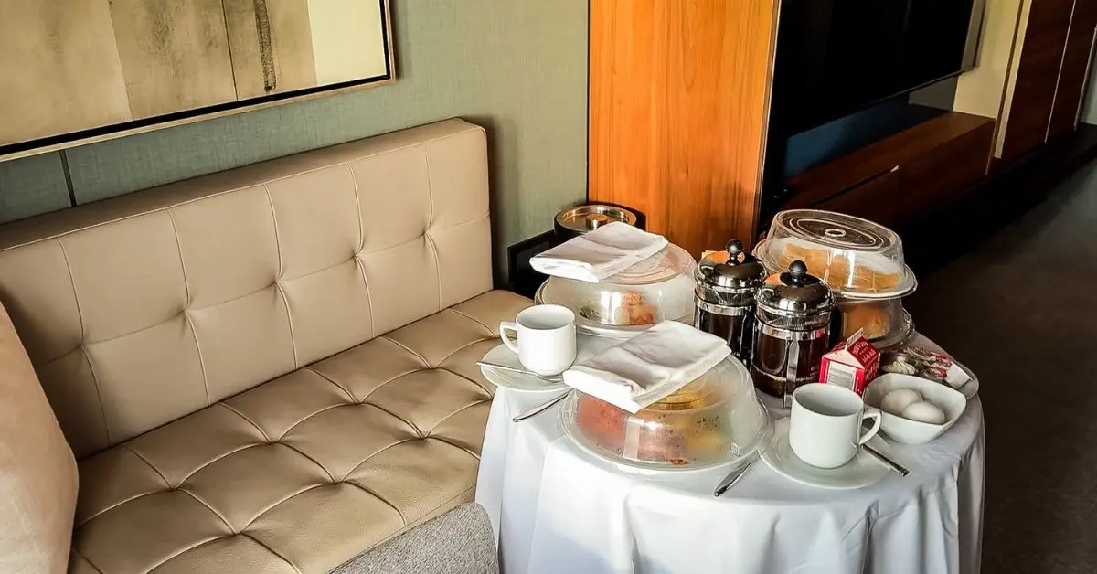 Norwegian Haven Butler breakfast setup with in-suite dining, coffee, and covered dishes in a Haven suite.
