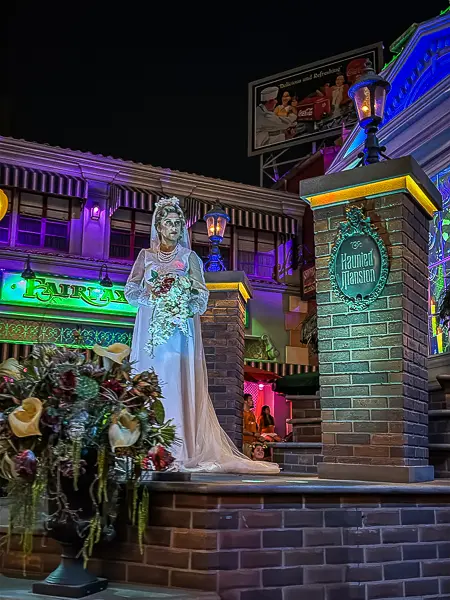 Constance Hatchaway, the Haunted Mansion Bride, holding a bouquet of flowers during Madame Leota’s Swinging Wake at Oogie Boogie Bash 2026.