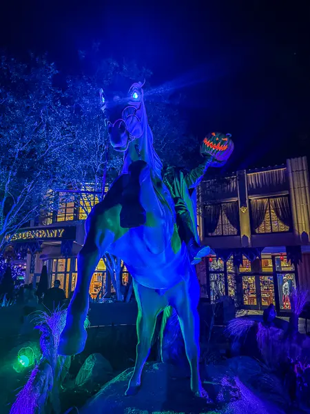 Headless Horseman Halloween display featuring a rearing horse and glowing jack-o'-lantern at Disney California Adventure.