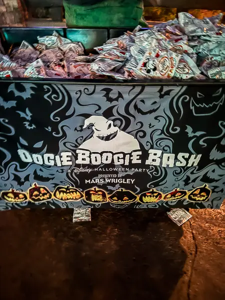 Oogie Boogie Bash trick-or-treat station filled with packaged candy and decorated with Halloween pumpkins at Disney California Adventure.