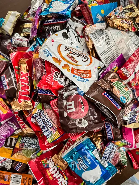 Assortment of Halloween candy collected at Oogie Boogie Bash 2026, including Snickers, M&M's, Twix, Skittles, and other treats.