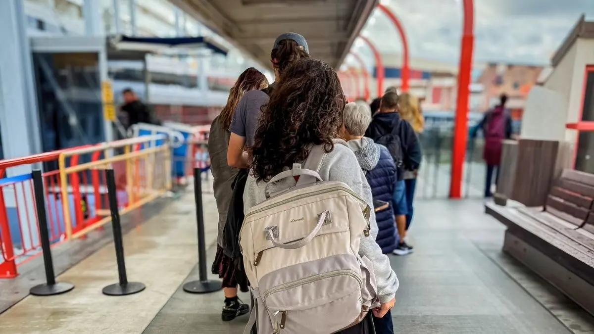 Kathy Ava wearing her cruise carry-on backpack while boarding a cruise ship on embarkation day.